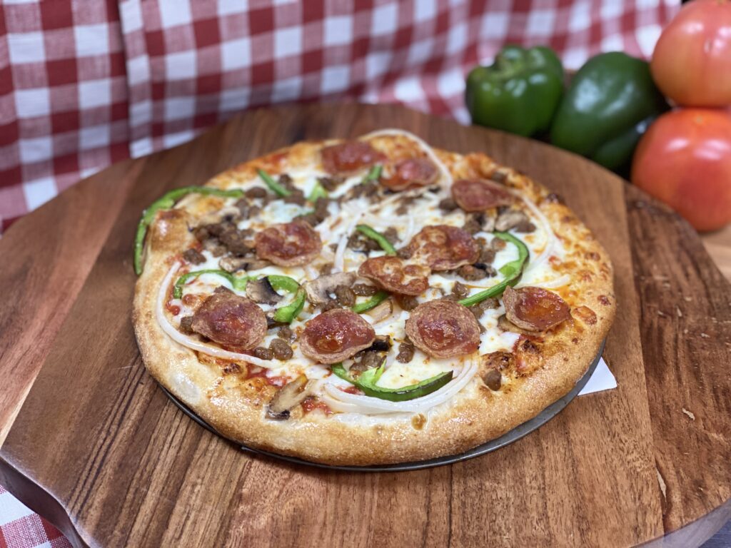 Delicious meat lovers pizza Delicious meat lovers pizza topped with pepperoni, sausage, green bell peppers, onions, and mushrooms on a crispy golden crust.