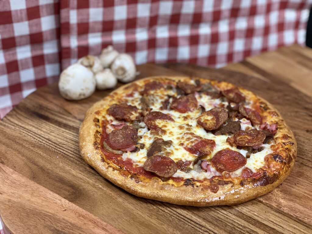 A freshly baked meat lovers pizza topped with pepperoni, sausage, and melted cheese.