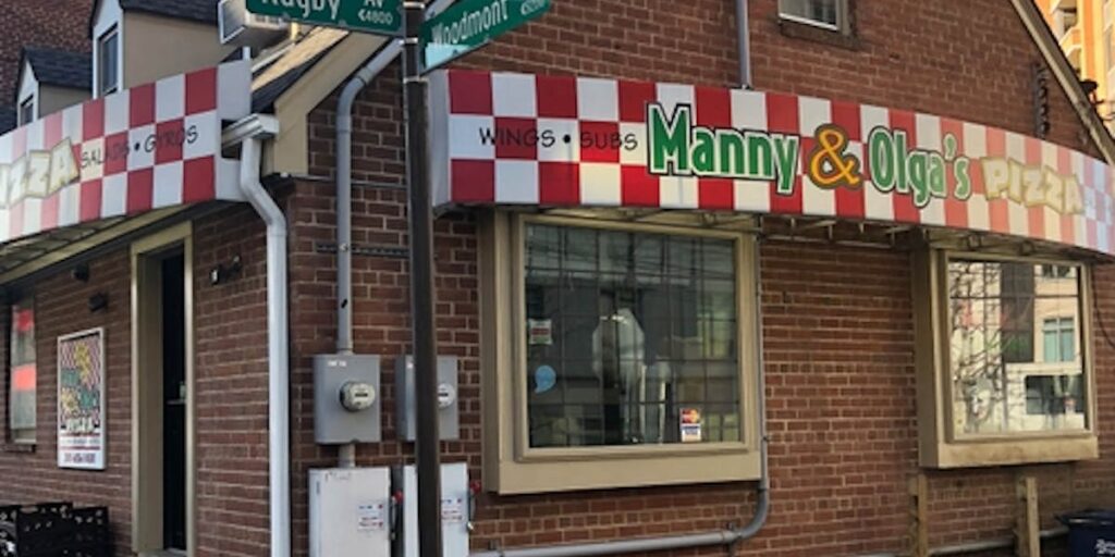 Manny & Olga's Pizza storefront, Manny & Olga's Pizza storefront, known for dishes like cheesy fries, with a red and white checkered awning.