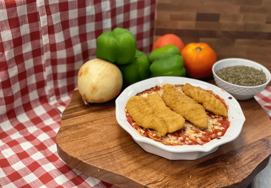 A tempting dish of the best pasta lasagna topped with crispy chicken strips, A tempting dish of the best pasta lasagna topped with crispy chicken strips, accompanied by fresh vegetables for a hearty meal.