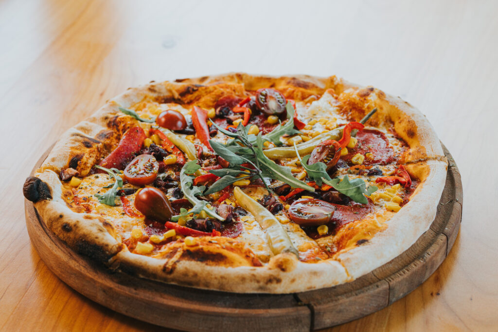 Fresh hand-tossed pizza dough on a floured surface, like at Manny & Olga’s kitchen.
