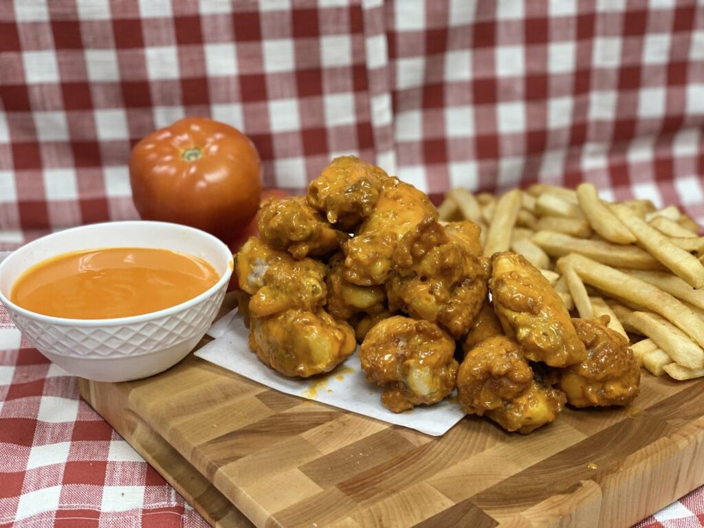 Crispy chicken wings, golden French fries, and a fresh tomato Crispy chicken wings, golden French fries, and a fresh tomato - a delicious side to complete your pizza and wings feast.