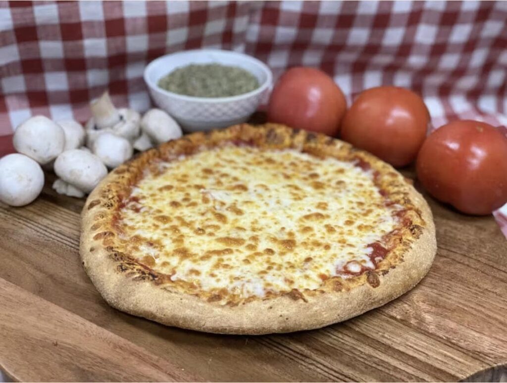 A freshly baked cheese pizza, crafted with the best ingredients A freshly baked cheese pizza, crafted with the best ingredients, surrounded by tomatoes, mushrooms, and herbs for an authentic Italian flavor.