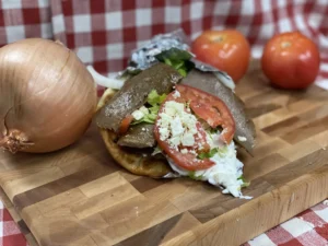 Manny & Olga's gyros with tzatziki sauce and shredded lettuce, all wrapped up in a pita.