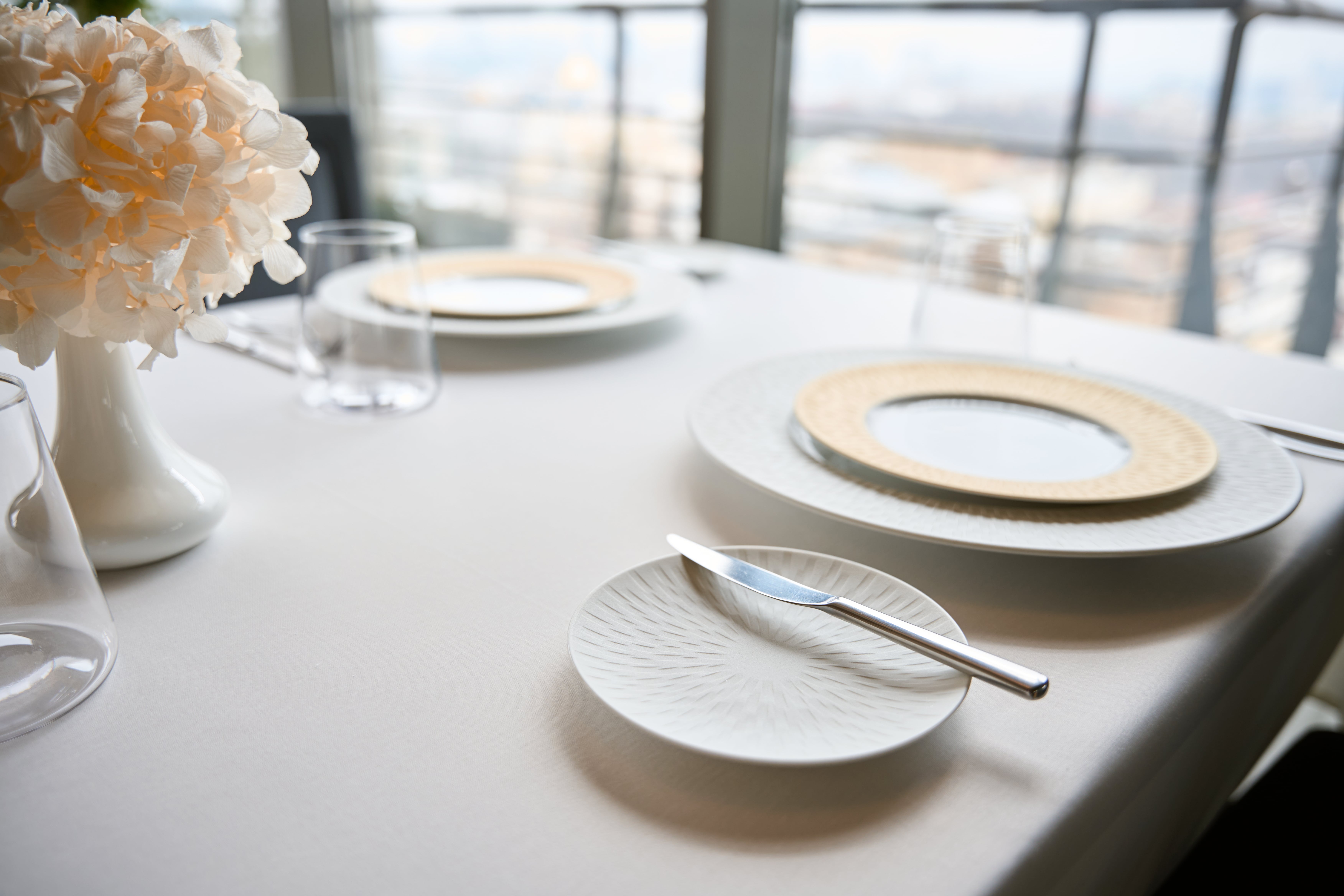 A tastefully set table with elegant tableware A tastefully set table with elegant tableware, hinting at a sophisticated dining experience.