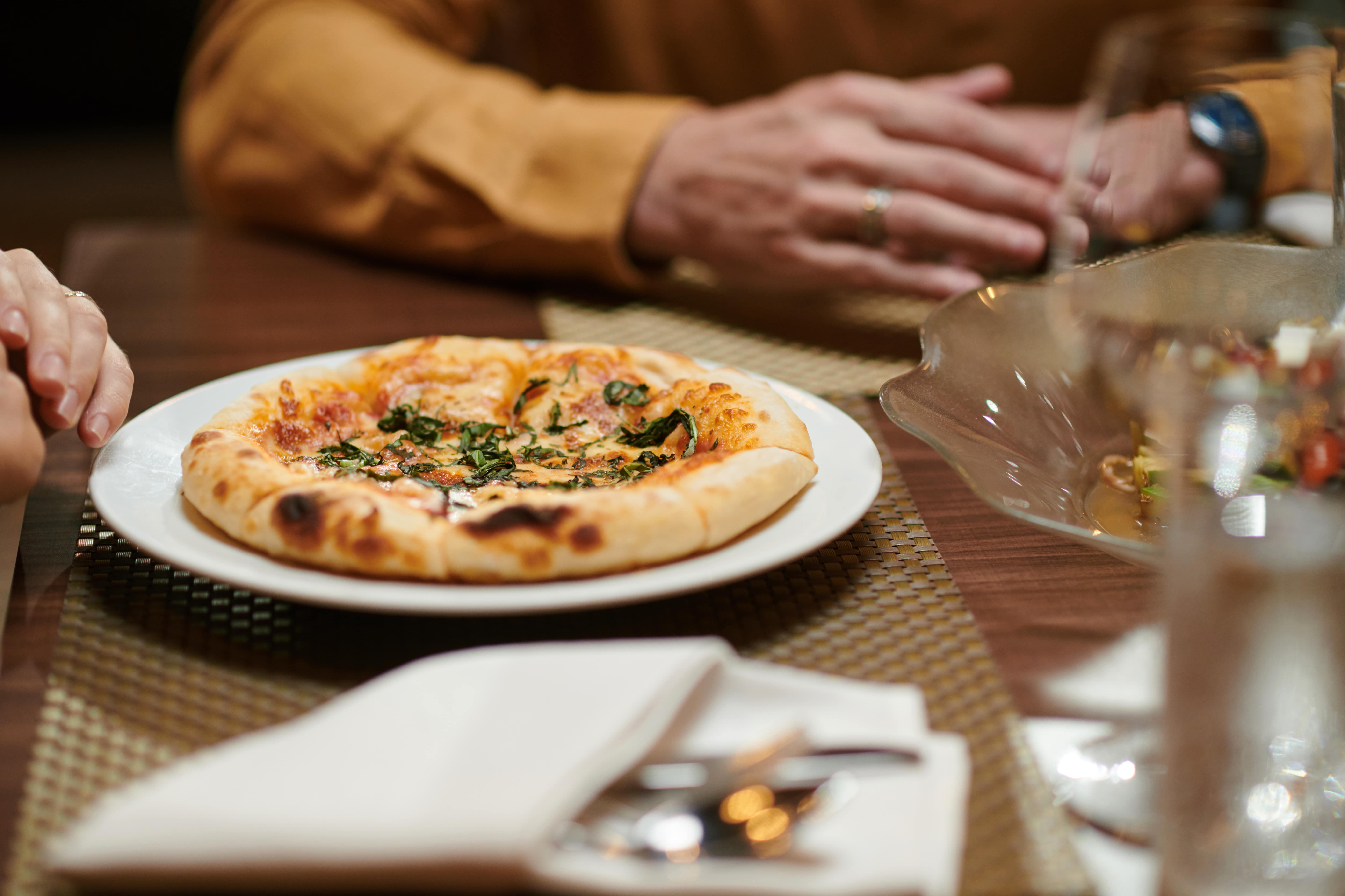 A close-up of a perfectly cooked pizza with melted cheese, fresh spinach, and a golden crust. This image evokes the deliciousness of a catered pizza feast in Washington DC, perfect for any gathering