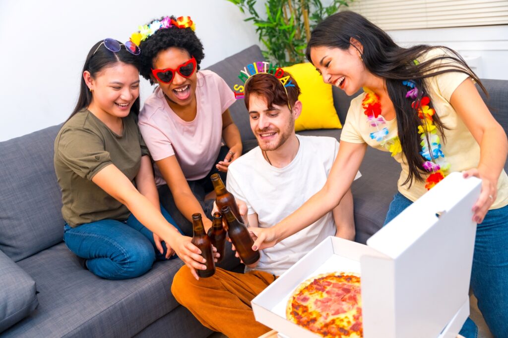 Friends enjoying a birthday party with pizza and beer.