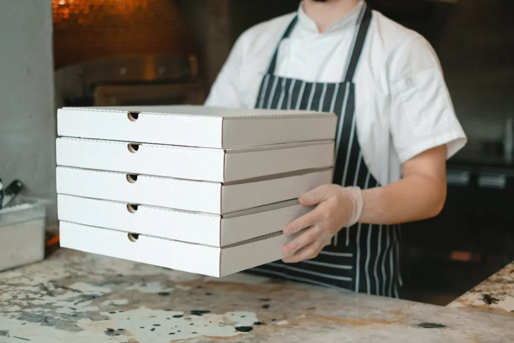 A person holds five pizza boxes for easy and fast delivery in Washington D.C.