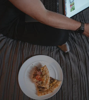 Flatlay shot of two slices of pizza being eaten as late-night snacks.