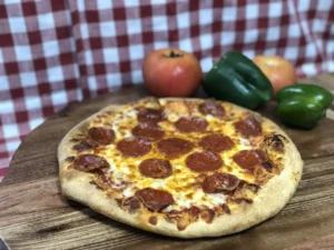 Pizza from Manny & Olga’s topped with tomatoes, green peppers, olives, and melted cheese.