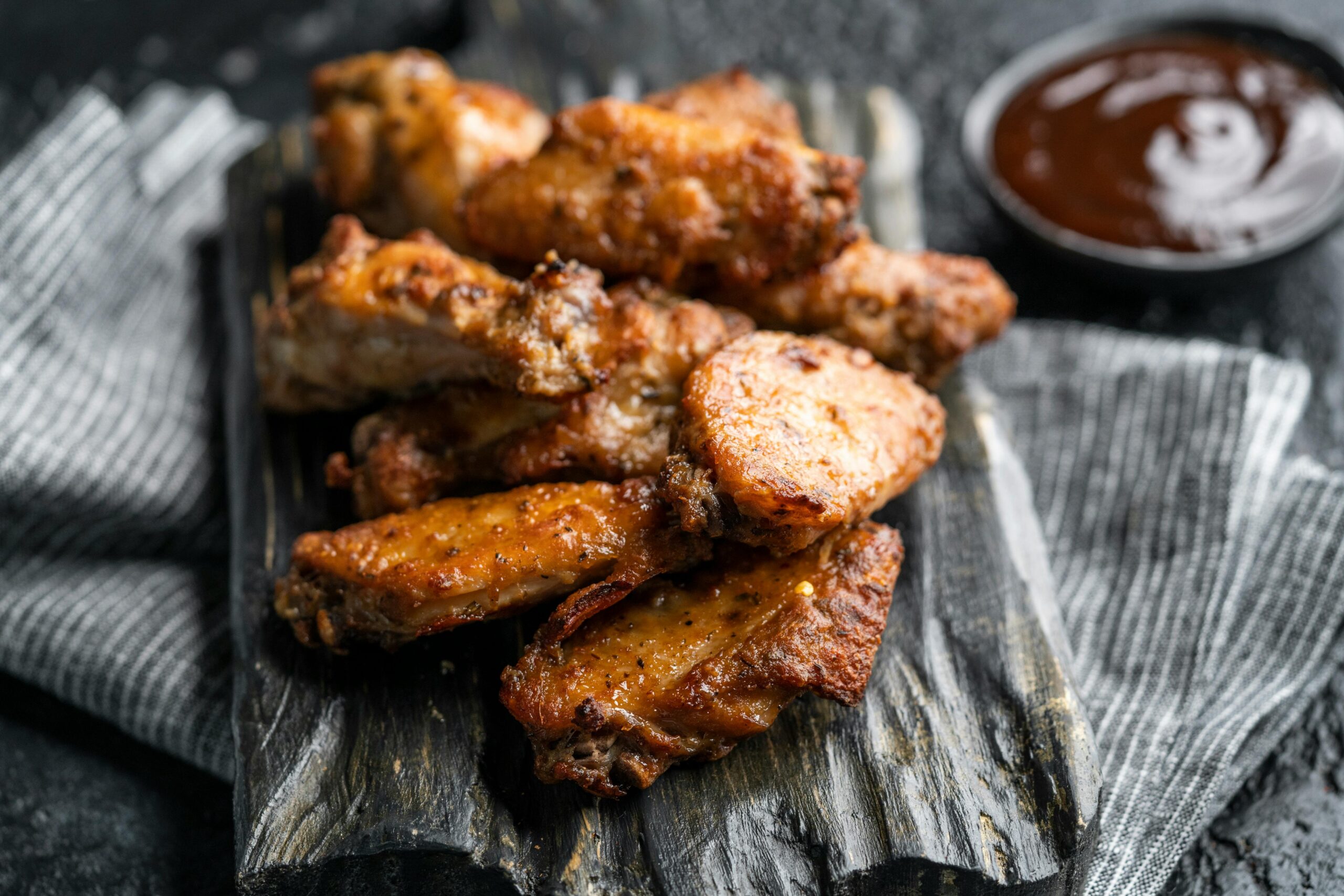 Close-up of crispy buffalo wings served with dipping sauce.