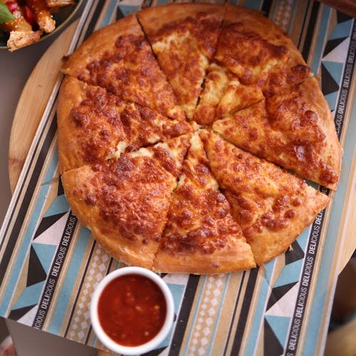 A flat-lay image of pizza with a variety of dipping sauces, offering diverse flavor options for every bite.