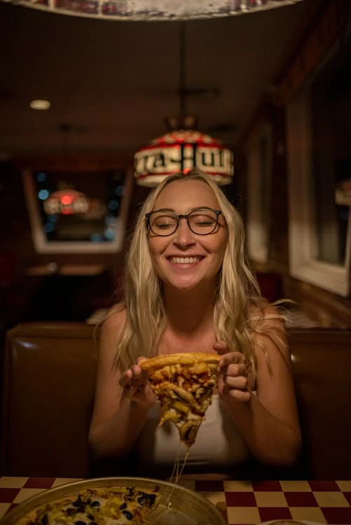 A person tries a topping-heavy cheesy slice of pizza at the best pizzeria in Washington.