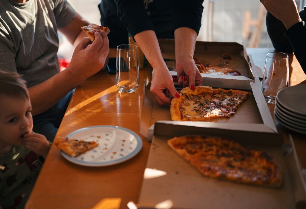 Family-style pizza service during a catered event, highlighting casual large-scale dining.