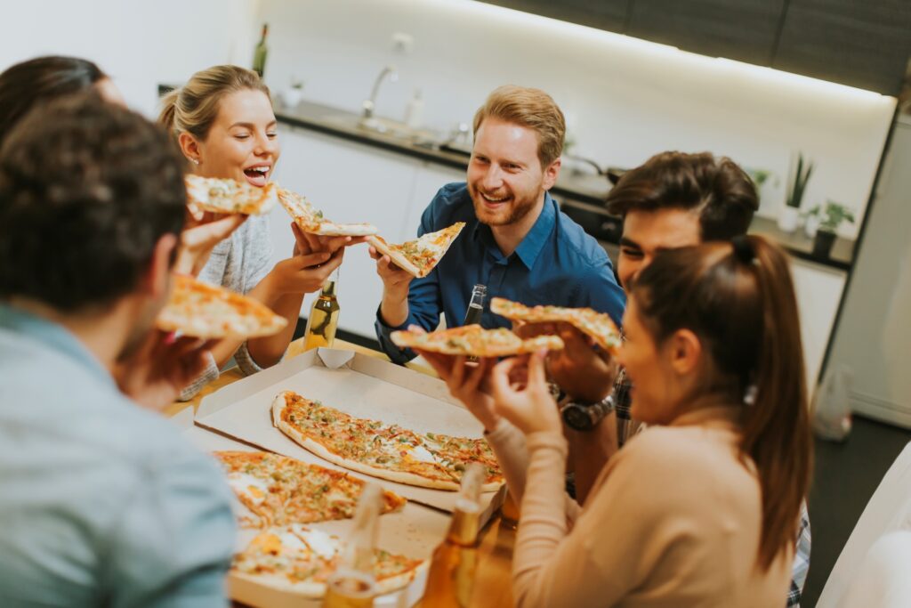 Guests enjoying catered pizza and drinks, showcasing social engagement and flavor presentation.