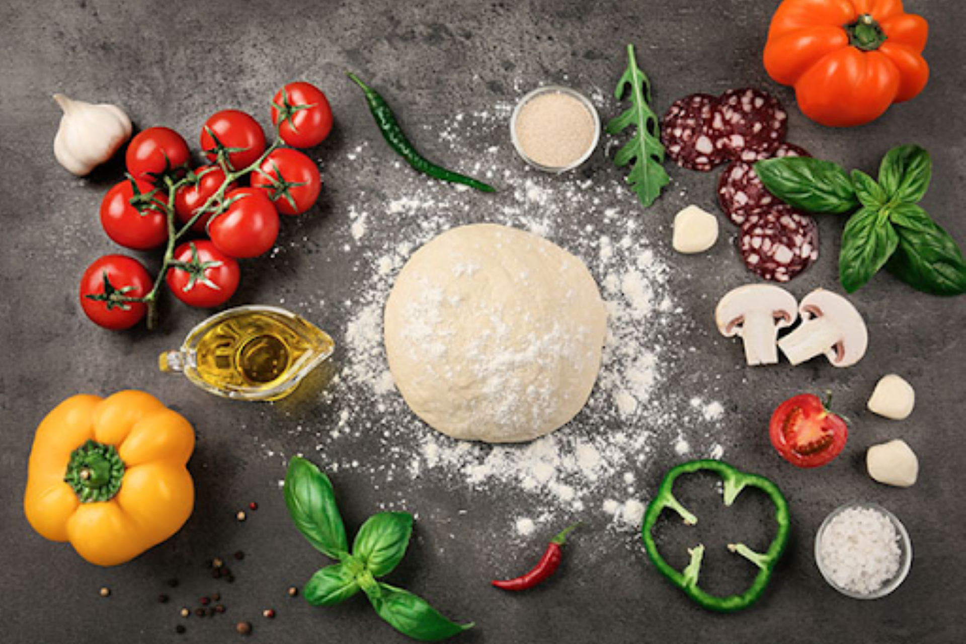 Fresh pizza dough surrounded by vibrant ingredients like tomatoes, mushrooms, and herbs, showcasing Manny & Olga’s quality.