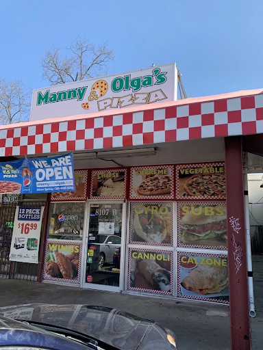 Exterior of Manny & Olga’s pizza restaurant with menu photos and open sign