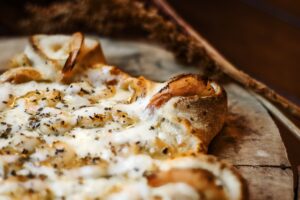 Cheesy shrimp-topped pizza with herbs and stuffed crust, ideal for an indulgent Mother's Day dinner from Manny & Olga’s.