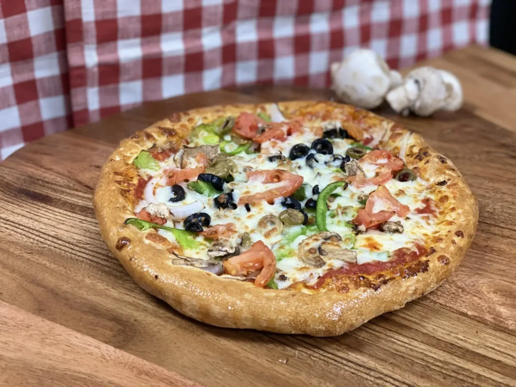 Fresh veggie pizza with mushrooms, tomatoes, and bell peppers from Manny & Olga’s, ideal for a light Mother’s Day brunch.