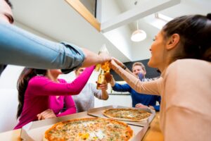 Family tossing with pizza slices around the table, celebrating Father’s Day in Manny and Olga’s way.