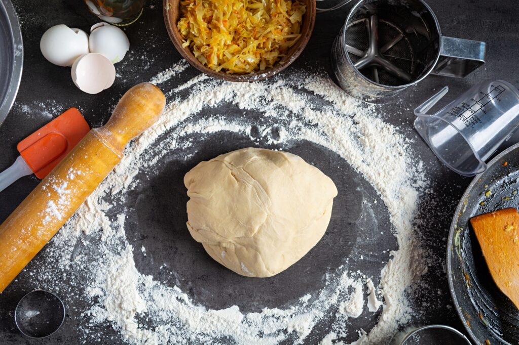 A chef prepares fresh dough for making pizza at Manny & Olga’s