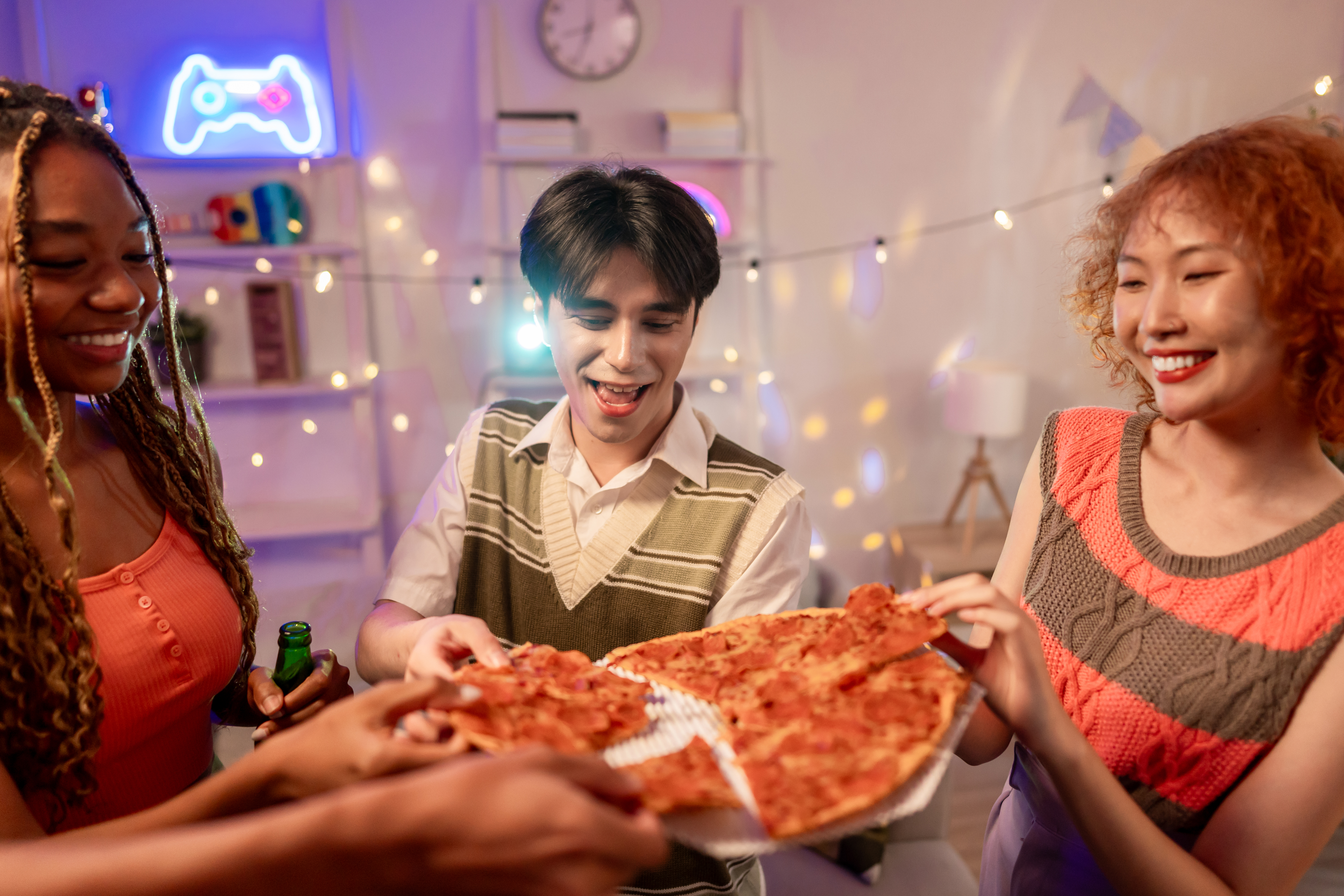 Group of friends enjoying fresh pizza together at home.