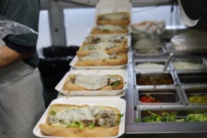 Manny & Olga’s cheesesteak subs lined up in a row, ready for office catering service.