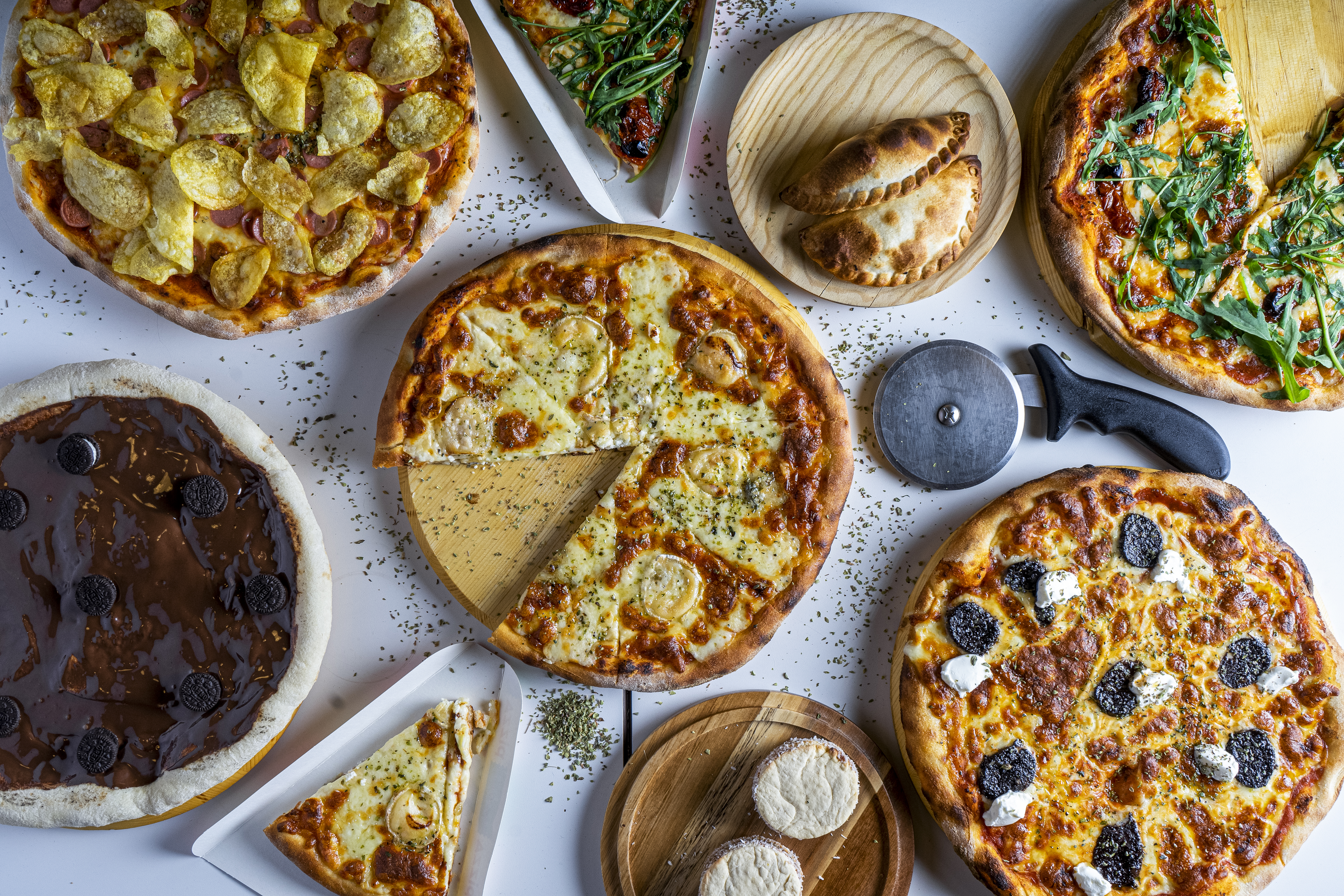 Variety of pizzas on a table served for sharing.