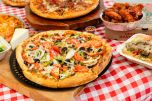 Manny & Olga’s vegetable pizza topped with onions, tomatoes, peppers, and black olives.