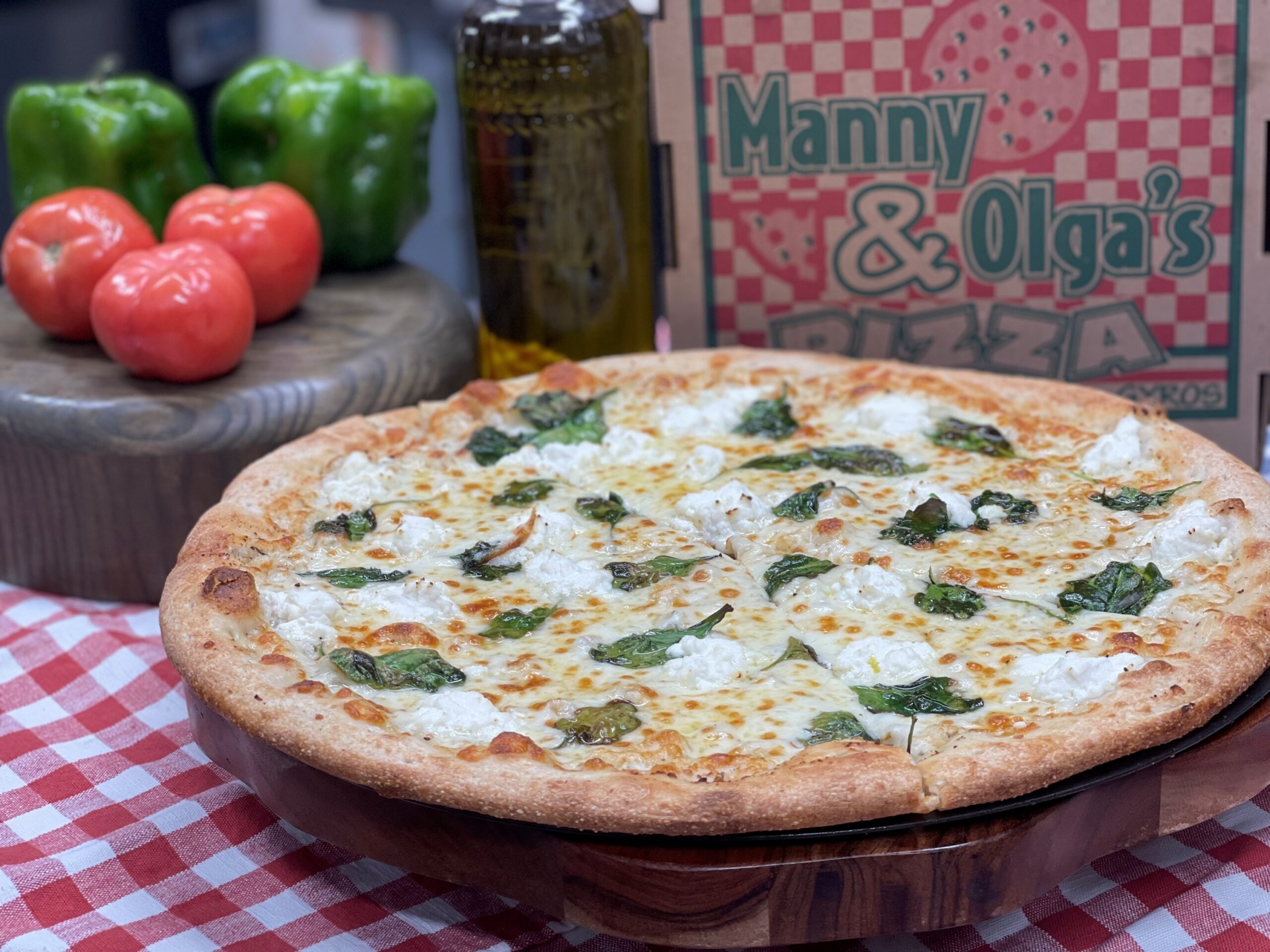 White pizza with spinach and cheese served fresh from Manny & Olga’s