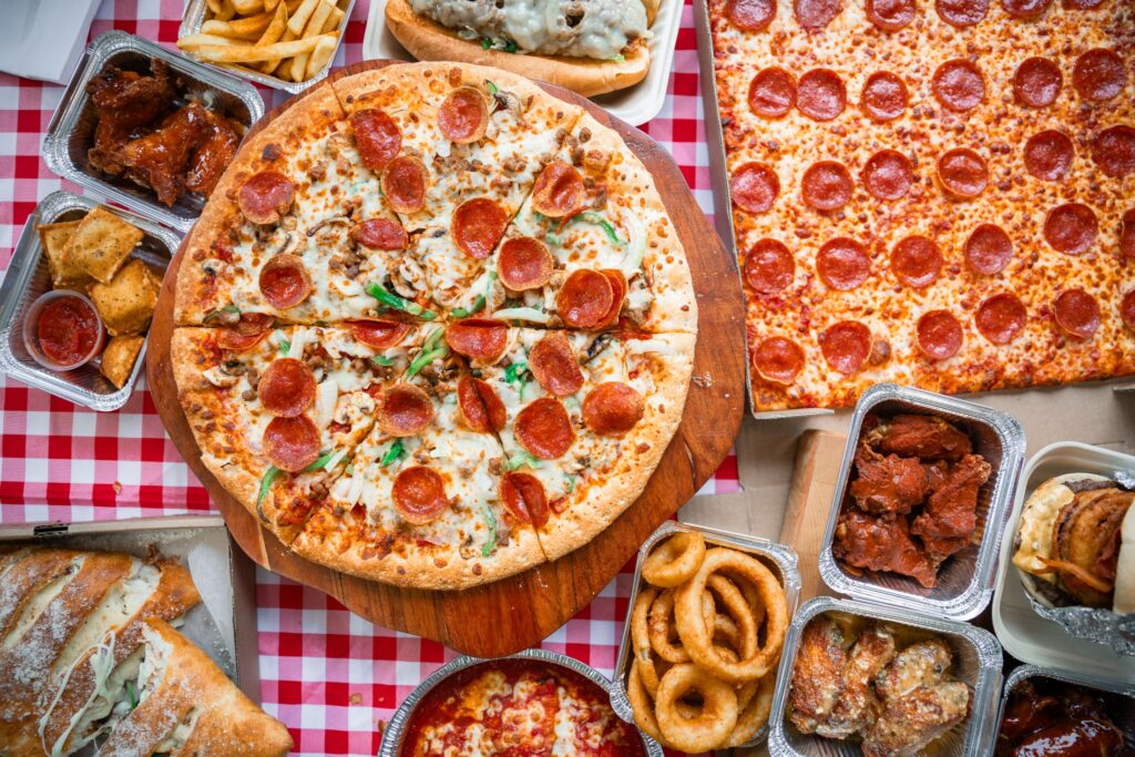 Manny and Olga’s pizza spread with wings, onion rings, subs, and pepperoni pies.