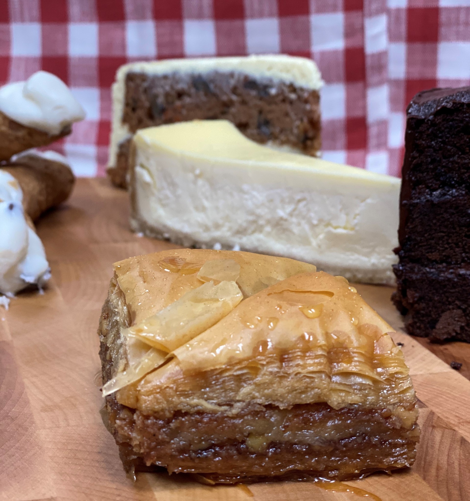 Manny and Olga’s baklava served with cheesecake, carrot cake, and chocolate cake on display.