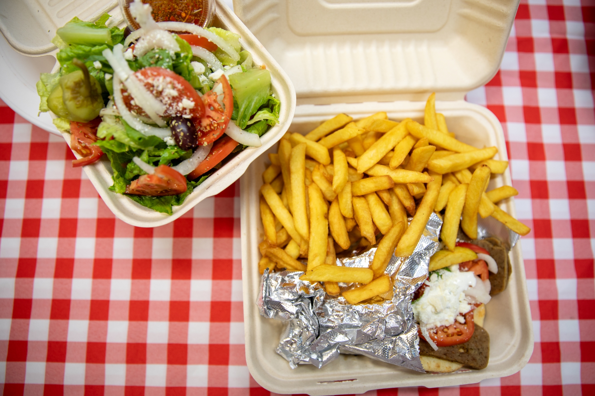 Manny and Olga’s gyro platter with crispy fries and Greek salad packed for carryout.