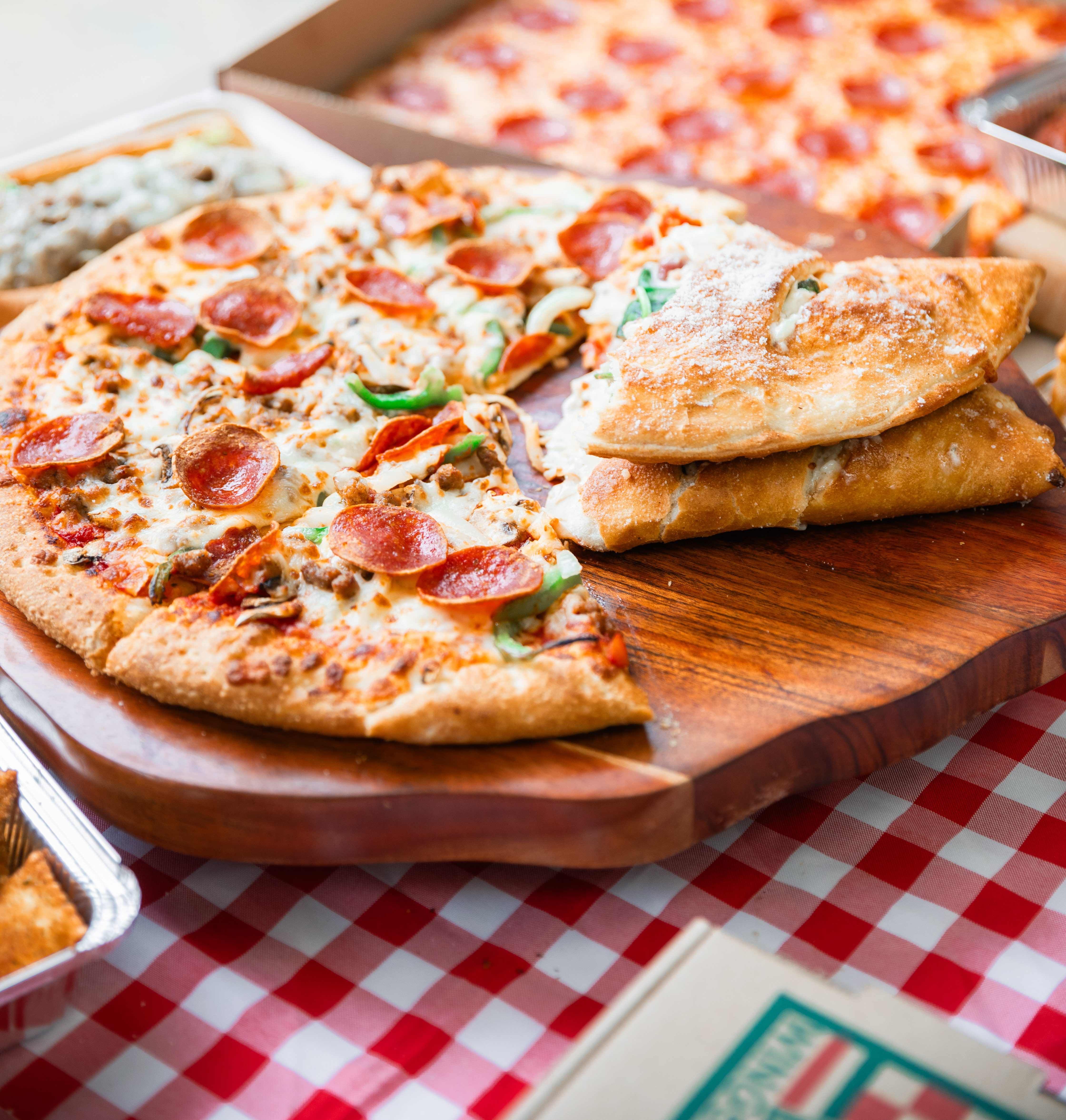Pepperoni pizza slices with a cannoli on a wooden serving board from Manny & Olga's, perfect for game night.