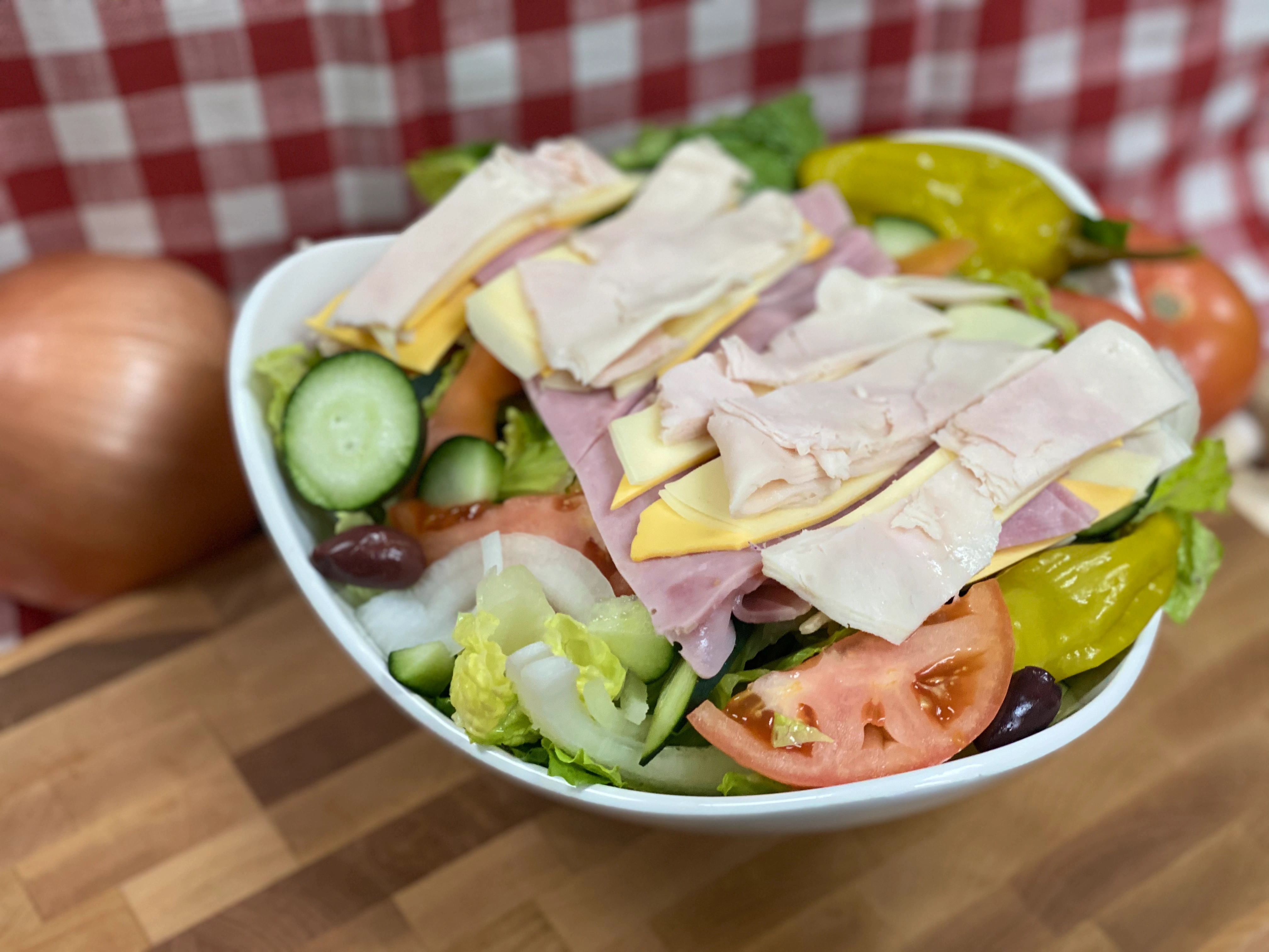 Manny & Olga's chef salad with turkey, ham, cheese, cucumbers, tomatoes, olives, and peppers.