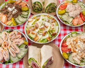 Manny & Olga’s spread of fresh salads and wraps with chicken, deli meats, vegetables, and croutons.