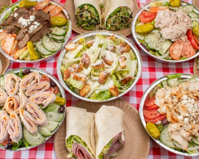 Manny & Olga’s spread of fresh salads and wraps with chicken, deli meats, vegetables, and croutons.