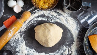 Chef preparing fresh pizza dough, emphasizing proper yeast activation for perfect rise and texture.